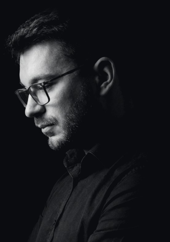 Portret Kamila Pionkowskiego na ciemnym tle